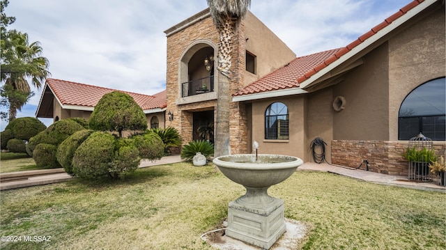 exterior space featuring a balcony and a front yard