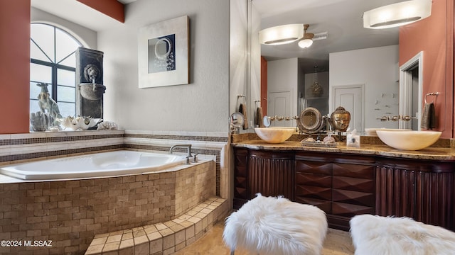 bathroom with vanity and a relaxing tiled tub