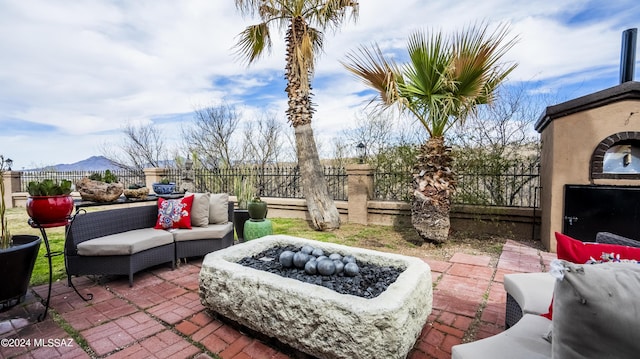 view of patio / terrace featuring a mountain view and an outdoor living space with a fire pit