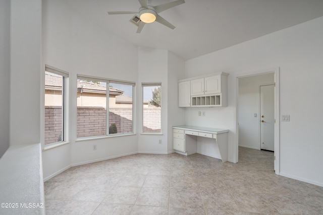 kitchen with ceiling fan and white cabinetry