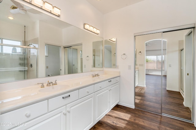 bathroom featuring wood-type flooring, vanity, ceiling fan, and a shower with shower door