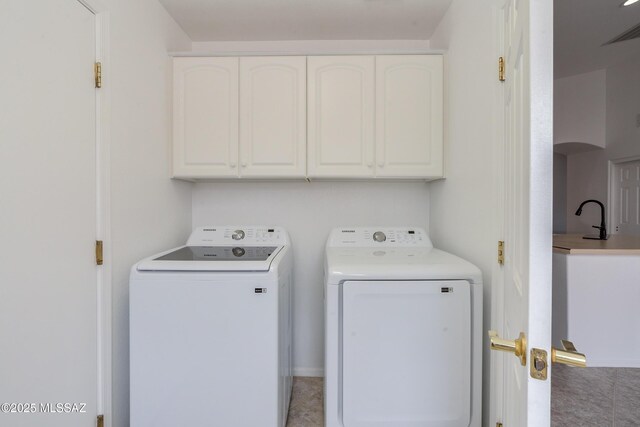 laundry room featuring sink and light tile patterned floors