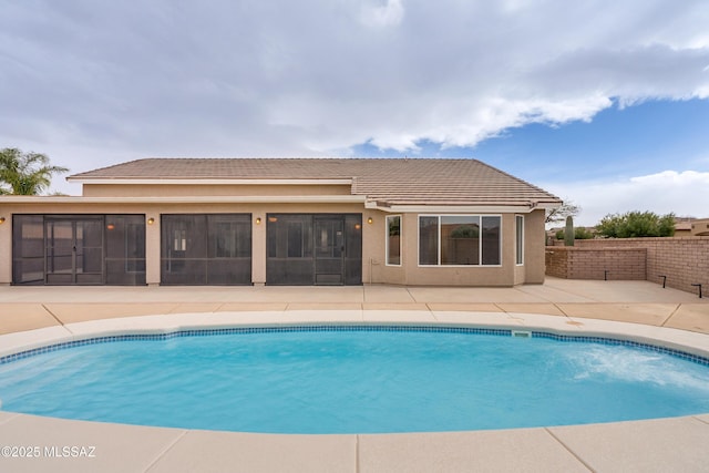 view of swimming pool with a patio and a sunroom