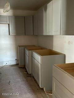 kitchen featuring washer / clothes dryer and white cabinets