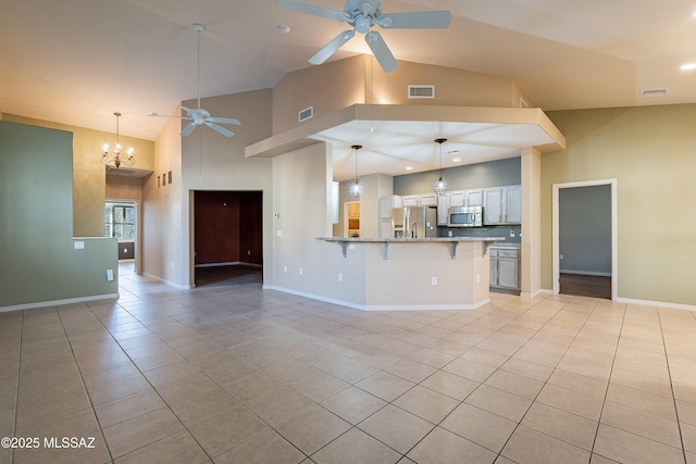 kitchen with hanging light fixtures, light tile patterned floors, kitchen peninsula, and appliances with stainless steel finishes