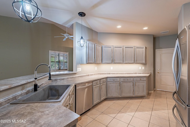 kitchen with pendant lighting, stainless steel appliances, light tile patterned floors, ceiling fan, and sink