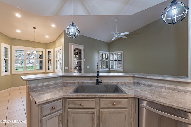 kitchen featuring vaulted ceiling, light tile patterned floors, sink, stainless steel dishwasher, and ceiling fan with notable chandelier