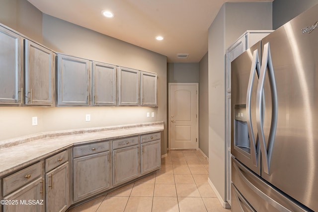 kitchen with stainless steel fridge with ice dispenser and light tile patterned flooring