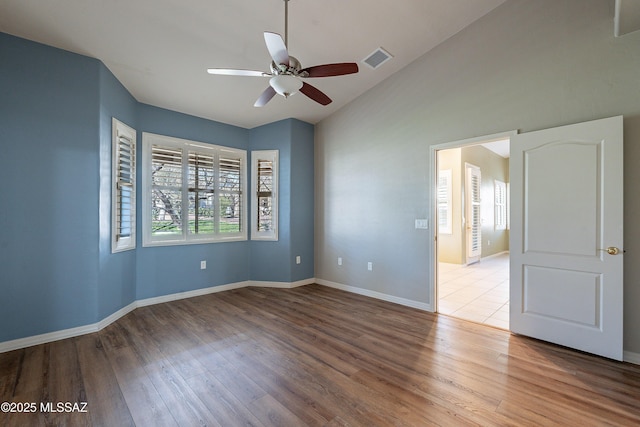 empty room with ceiling fan, light hardwood / wood-style flooring, and lofted ceiling