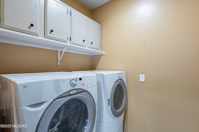 washroom featuring cabinets and washing machine and clothes dryer