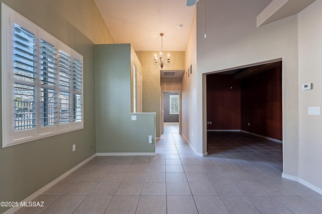 interior space featuring high vaulted ceiling, light tile patterned flooring, and a chandelier