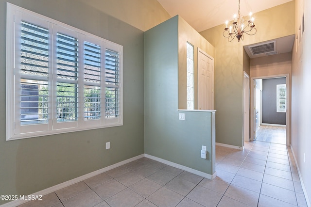 entrance foyer with light tile patterned flooring and a chandelier