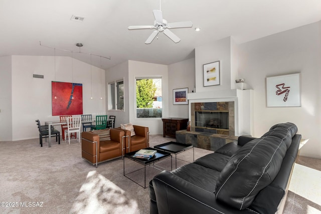 living room with ceiling fan, lofted ceiling, light colored carpet, and a tile fireplace