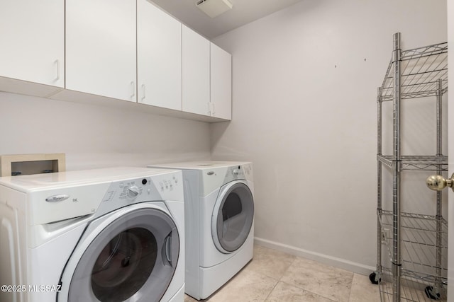 washroom featuring cabinets, light tile patterned floors, and washing machine and clothes dryer