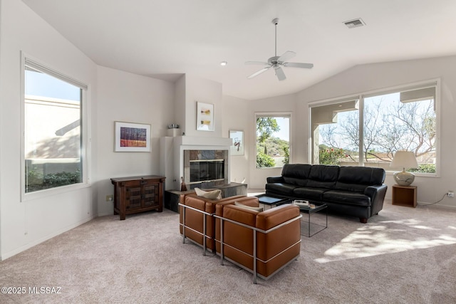 carpeted living room with ceiling fan and lofted ceiling