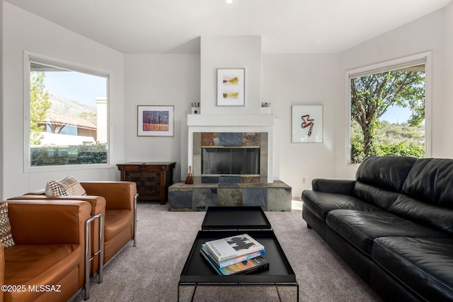 living room with light carpet and a tile fireplace