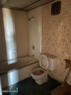 bathroom featuring washtub / shower combination and toilet