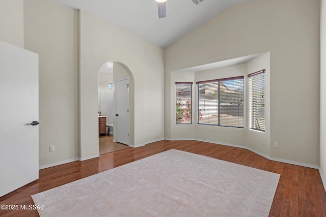 empty room featuring hardwood / wood-style floors, high vaulted ceiling, and ceiling fan