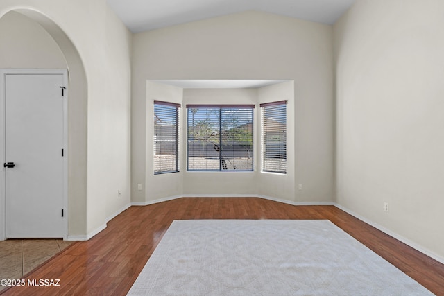 empty room featuring wood-type flooring and lofted ceiling