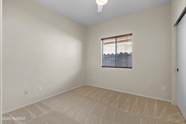 spare room with ceiling fan and light carpet