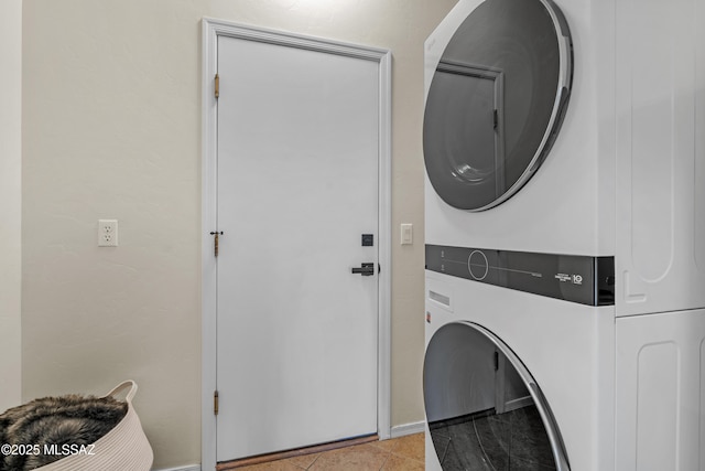 laundry room with light tile patterned flooring and stacked washer / dryer