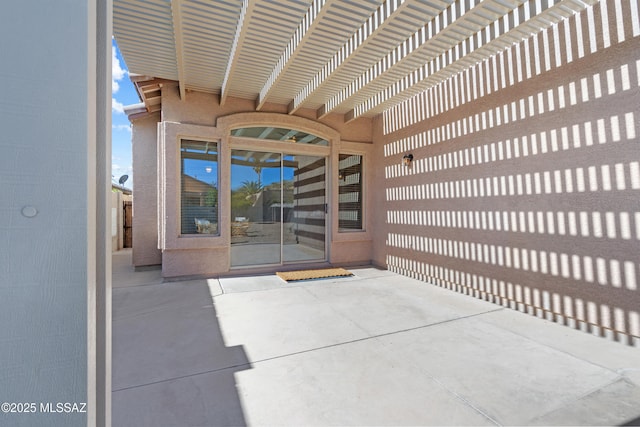 property entrance with a pergola and a patio