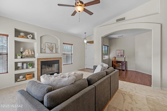 living room with vaulted ceiling, plenty of natural light, light carpet, and built in features