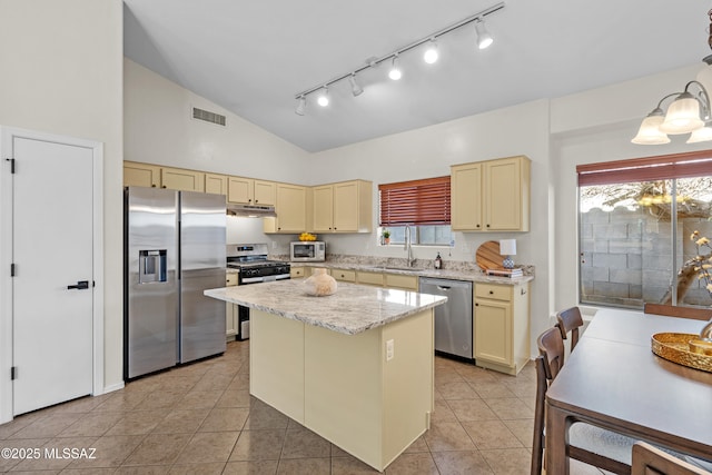 kitchen featuring sink, light tile patterned floors, stainless steel appliances, and a kitchen island