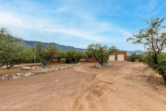 view of yard featuring a mountain view and a garage