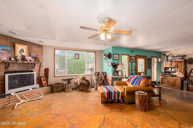 living room featuring ceiling fan and a textured ceiling