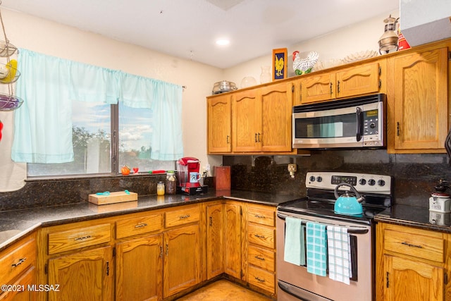 kitchen with a wealth of natural light, decorative backsplash, and appliances with stainless steel finishes