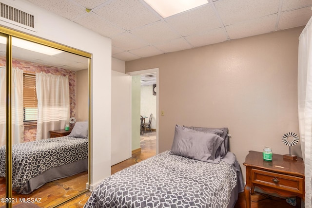 bedroom with a paneled ceiling and a closet