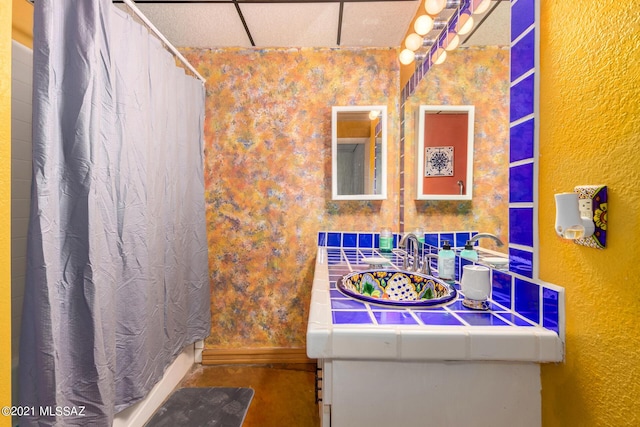 bathroom with a paneled ceiling and vanity