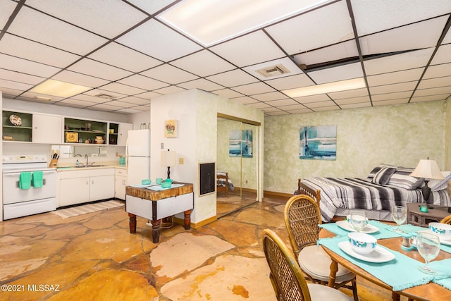 dining area with a paneled ceiling and sink