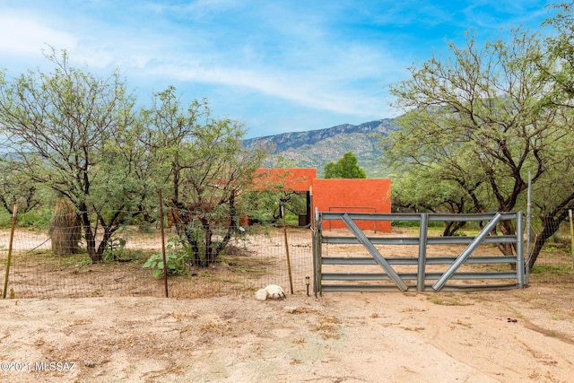 view of gate with a mountain view and a rural view