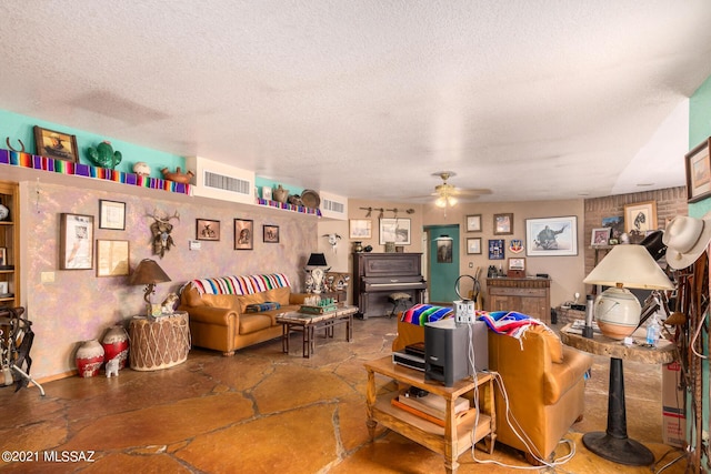 living room with ceiling fan and a textured ceiling