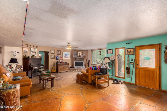 living room featuring ceiling fan and a textured ceiling