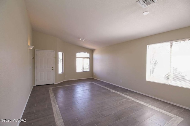 entryway featuring baseboards, lofted ceiling, and visible vents