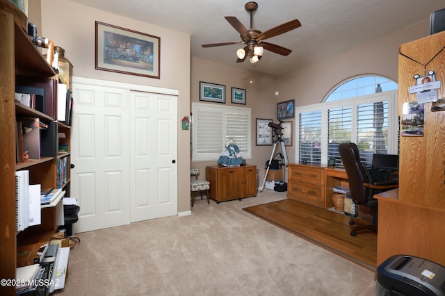 carpeted home office featuring ceiling fan