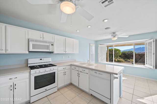 kitchen featuring white appliances, white cabinetry, light tile patterned floors, sink, and kitchen peninsula