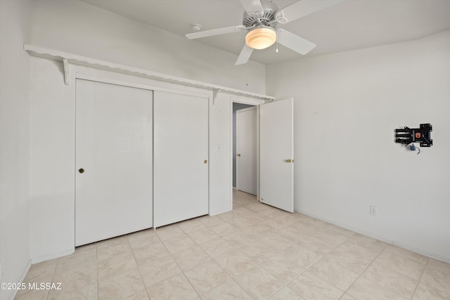 unfurnished bedroom featuring ceiling fan and a closet