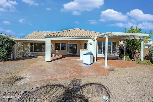 back of property with ceiling fan, a patio, and a pergola