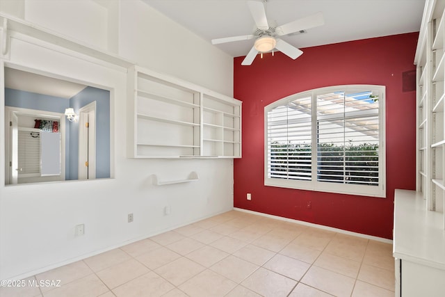 empty room with ceiling fan and tile patterned flooring