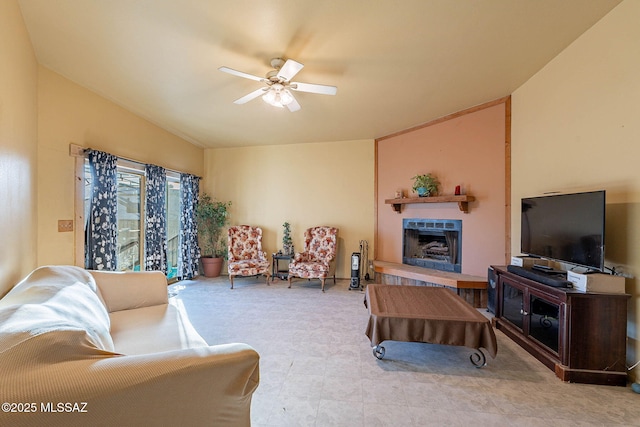 living room with a large fireplace, ceiling fan, and lofted ceiling