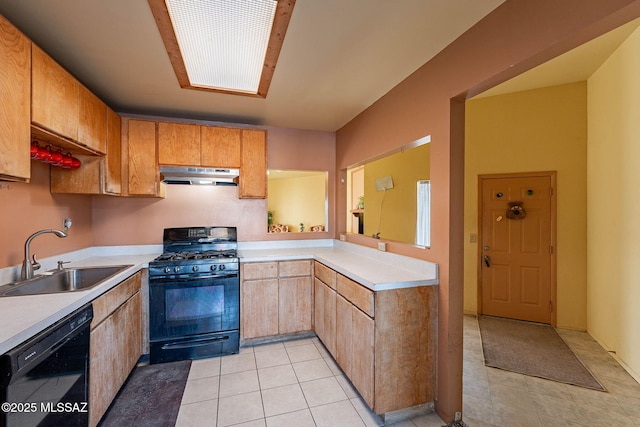 kitchen with black appliances, under cabinet range hood, light countertops, and a sink