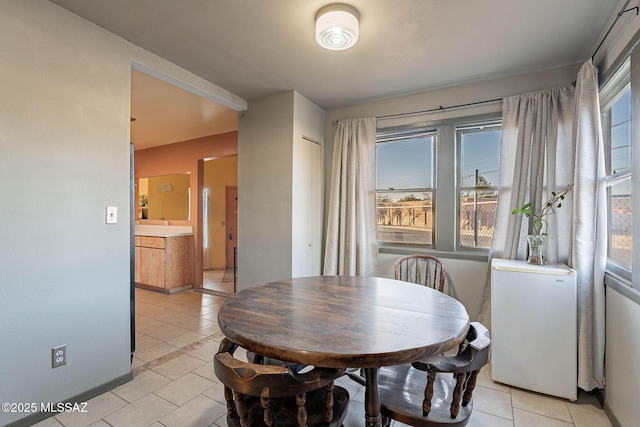 dining area featuring light tile patterned floors and baseboards