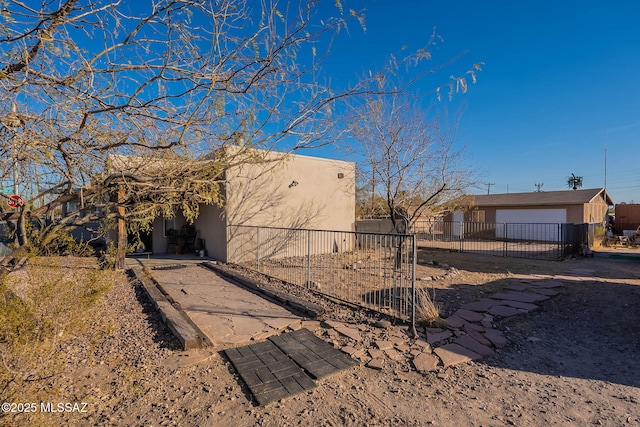 view of side of property featuring fence and stucco siding