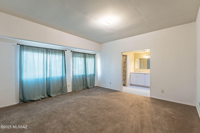 unfurnished room featuring carpet floors, a textured ceiling, and baseboards