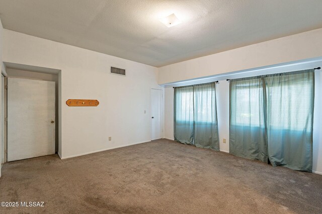 carpeted spare room with a textured ceiling