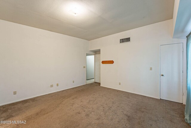 carpeted empty room with a textured ceiling